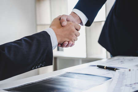 Business handshake after discussing and analysis graph stock market trading good deal of Trading to...