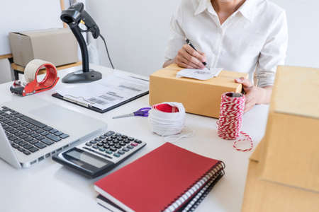 Small business owner delivery service and working packing box, business owner working checking order to confirm before sending customer in post office, Shipment Online Sales.の写真素材