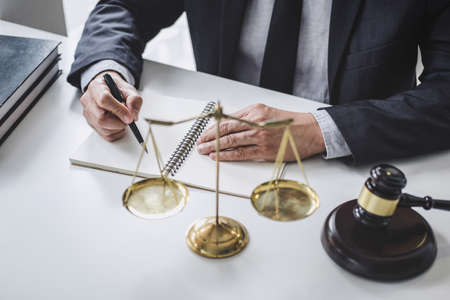 Male lawyer or judge working with contract papers, Law books and wooden gavel on table in courtroom, Justice lawyers at law firm, Law and Legal services concept.の写真素材