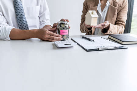 Real estate broker agent consult to customer to decision making sign insurance form and sending house model to client after approve, home model mortgage loan offer for and house insurance.の写真素材