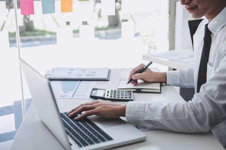 Professional at work, businessman working and analyzing on laptop with calculate statistics of...