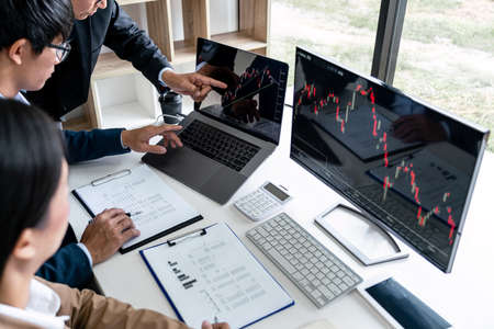 Business team partner working with computer, laptop, discussion and analyzing graph stock market...