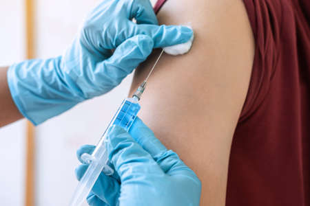 Doctor making injection vaccination patient to prevent pandemic of the disease, flu or influenza...