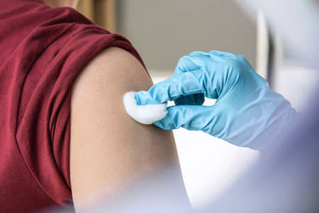 Doctor making injection vaccination patient to prevent pandemic of the disease, flu or influenza virus in clinic.の写真素材