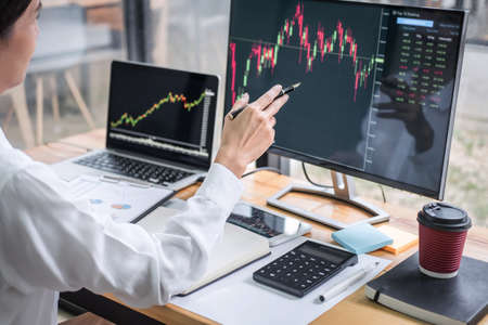 Businesswoman working with computer, laptop, thinking and analyzing graph stock market trading with...