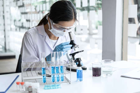 Scientist or medical in lab coat working in biotechnological laboratory, Microscope equipment for...