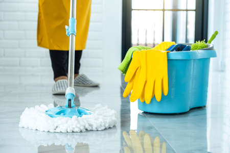 Wife housekeeping and cleaning concept, Happy young woman in blue rubber gloves wiping dust using...