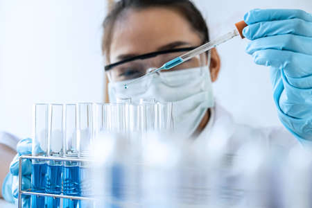 Biochemistry laboratory research, Chemist is analyzing sample in laboratory with equipment and...
