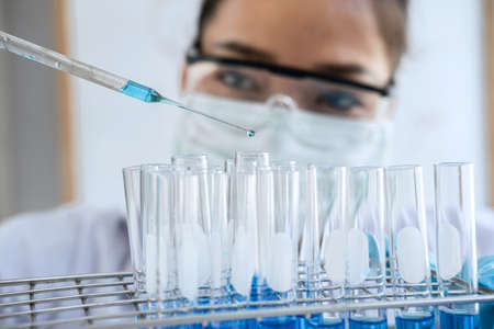 Biochemistry laboratory research, Chemist is analyzing sample in laboratory with equipment and...