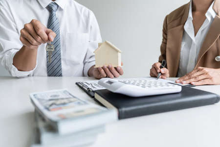 Real estate agent Sales manager holding filing keys to customer after signing rental lease contract...