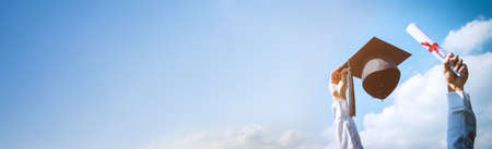 Images of graduate are celebrating graduation Throwing hands up a certificate and Cap in the air, Happiness cheerful feeling, Commencement, Graduation day on sky banner background.の写真素材