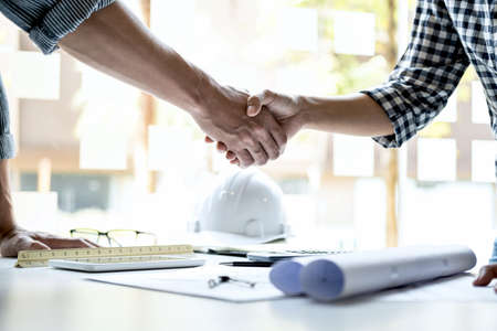Finishing up a meeting, Two engineer or architect meeting for project, handshake after consultation and conference new project plan, contract for both companies, success, partnership.の写真素材
