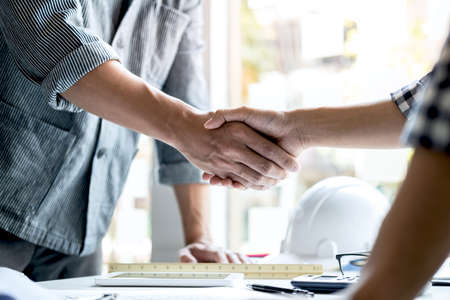 Finishing up a meeting, Two engineer or architect meeting for project, handshake after consultation and conference new project plan, contract for both companies, success, partnership.の写真素材