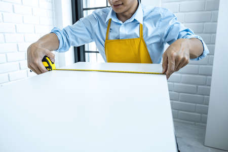 Craftsman doing renovation work at home improvement with measure wooden floor and interior design concept.の写真素材