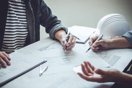 Construction and structure concept of Engineer or architect meeting for project working with partner and engineering tools on model building and blueprint in working site, contract for both companies.の写真素材