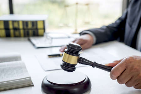 Judge gavel with Justice lawyers, Counselor in suit or lawyer working on a documents in courtroom, Legal law, advice and justice concept.の写真素材