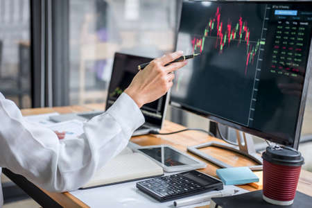 Businesswoman working with computer, laptop, thinking and analyzing graph stock market trading with...