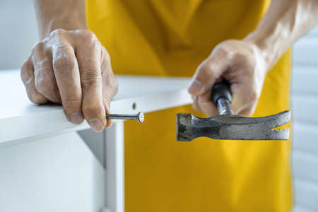 Craftsman doing renovation work at home improvement with using hammer to driving nail on wood and interior design concept.の写真素材