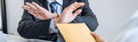 Anti Bribery and corruption concept, bribe in the form of dollar bills, consultant refuse receive money from business woman while making deal to agreement a real estate corporate contract.の写真素材