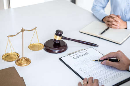 Consultation and conference of Male lawyers and professional businesswoman working and discussion having at law firm in office. Concepts of law, Judge gavel with scales of justice.の写真素材