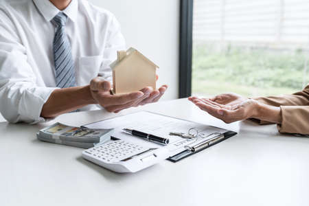 Real estate broker agent consult to customer to decision making sign insurance form and sending house model to client after approve, home model mortgage loan offer for and house insurance.の写真素材
