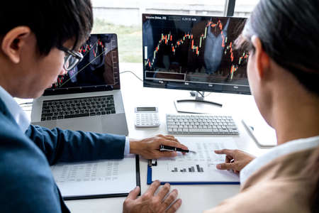 Business team partner working with computer, laptop, discussion and analyzing graph stock market...