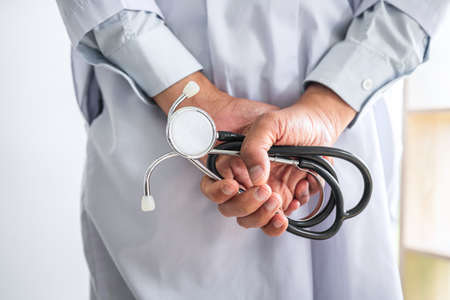 Close up of Mature doctor holding a stethoscope in hospital.の写真素材