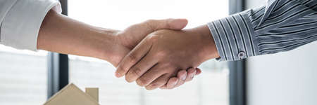 Real estate agent and customers shaking hands together celebrating finished contract after signing about home insurance and investment loan, handshake and successful deal.の写真素材