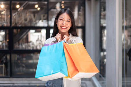 Portrait of Asian girl excited beautiful girl happy smiling with holding shopping bags relaxed...