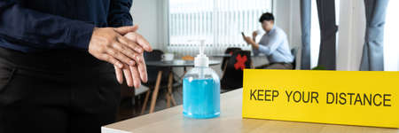 Close up of asian woman customer using alcohol antiseptic gel to wash her hand before entering...