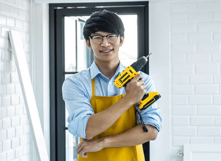 Portrait of Craftsman doing renovation work at home improvement with holding drill and interior...