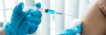 Doctor in medical glove holding syringe and using cotton before injection virus vaccine in shoulder...
