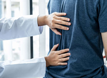 Female physiotherapist is checking spine of patient to doing healing treatment and rehabilitation...