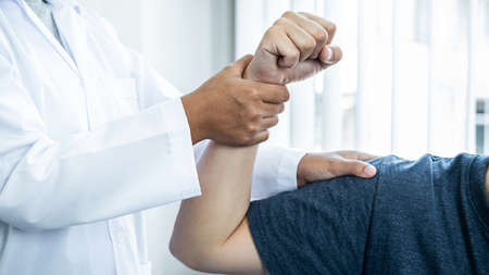 Female physiotherapist doing healing treatment and rehabilitation after injury shoulder of patient...