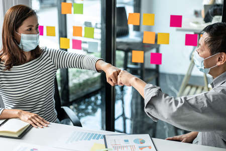 Business team making a fist-bump after mission complete during meeting together to brainstorming...