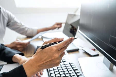 Business team two colleagues working with computer, discussing and analysis graph stock market trading with stock chart data, financial and investment concept.の写真素材
