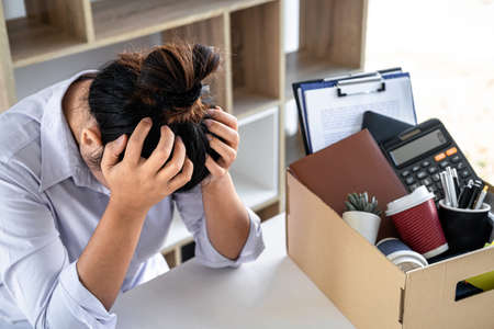 Images of business woman carrying packing up all his personal belongings and files into a brown...