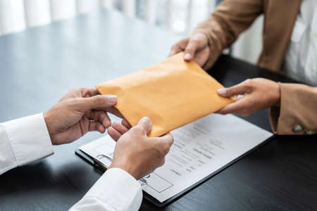 Bribe employer offer terms to a businessman for signing on contract while making corruption about real estate.の写真素材