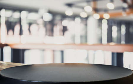 Empty wooden table and blurred background of abstract in front of restaurant or coffee shop for...
