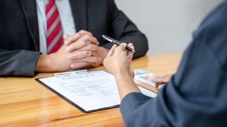 Bribe employer is handing over a pen and offer terms to businessman for signing on contract while...