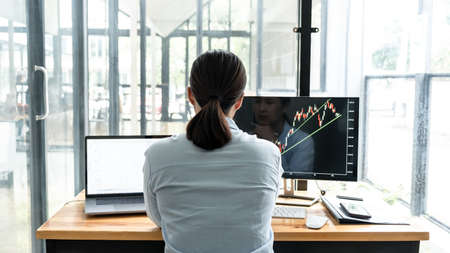 Businesswoman investor having planning and analyzing graph data with display screen the data...