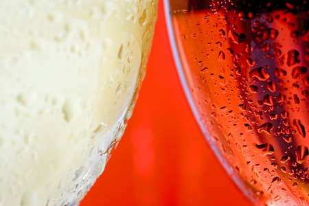 Macro close up of side of wine glass with white and red or rose wine covered with droplets of waterの写真素材