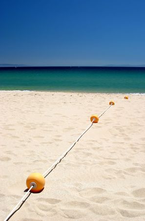 String of buoys on sunny hot tarifa beach in Southern Spain の写真素材