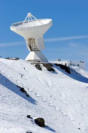 Snowy ski slopes of Prodollano ski resort in the Sierra Nevada mountains in Spain with large telescope and observatoryの写真素材