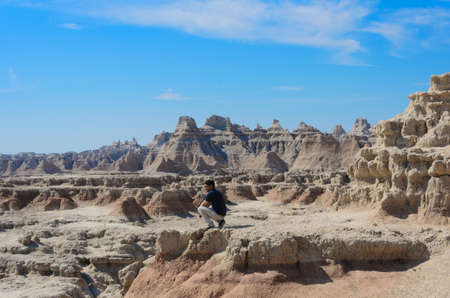a man stand at badlands geological formations, Scenic view of the Badlands National Parkの写真素材