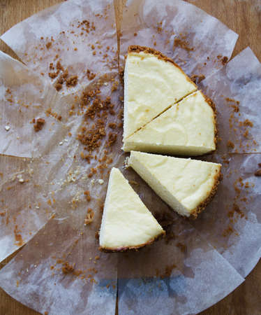 Pieces of delicious homemade cheesecake, lying on a wooden backgroundの写真素材