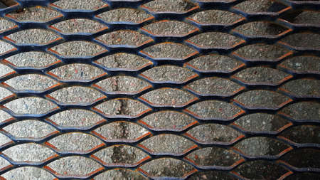 An old rusty grill with diamond shaped holesの写真素材