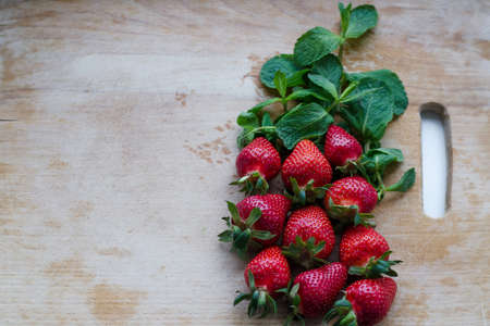Strawberries on a wooden cutting board. Copy space