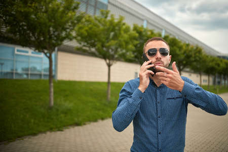 Man arguing over smart phone. Ouch someone is mad at me. Portrait of intense displeased young...