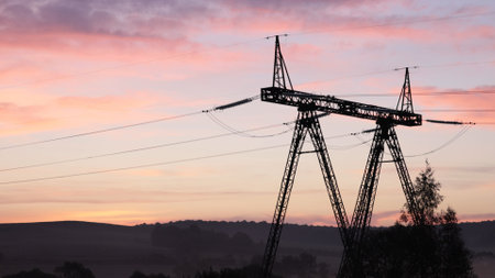 Tower shadows, Steel pylons, Energy stream. Sunrise cast long shadows from steel pylons providing infrastructure for countryside power grid.の写真素材